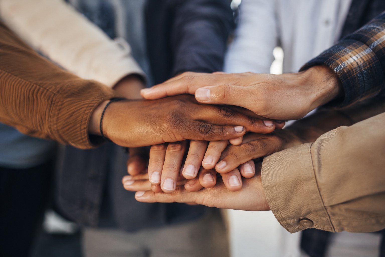 Hands stacked together to represent teamwork and partnership